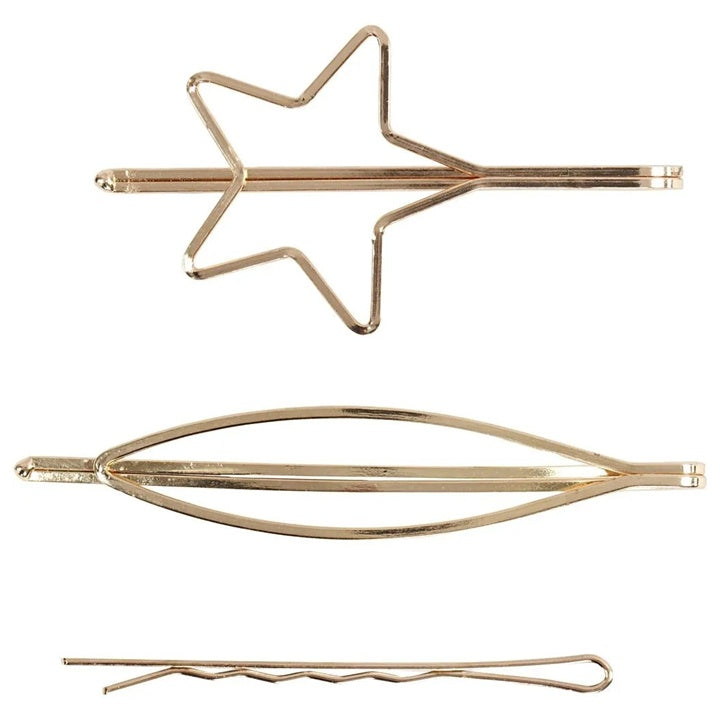 Drei goldfarbene Haarspangen aus Metall in unterschiedlichen Formen wie Stern und Linien.