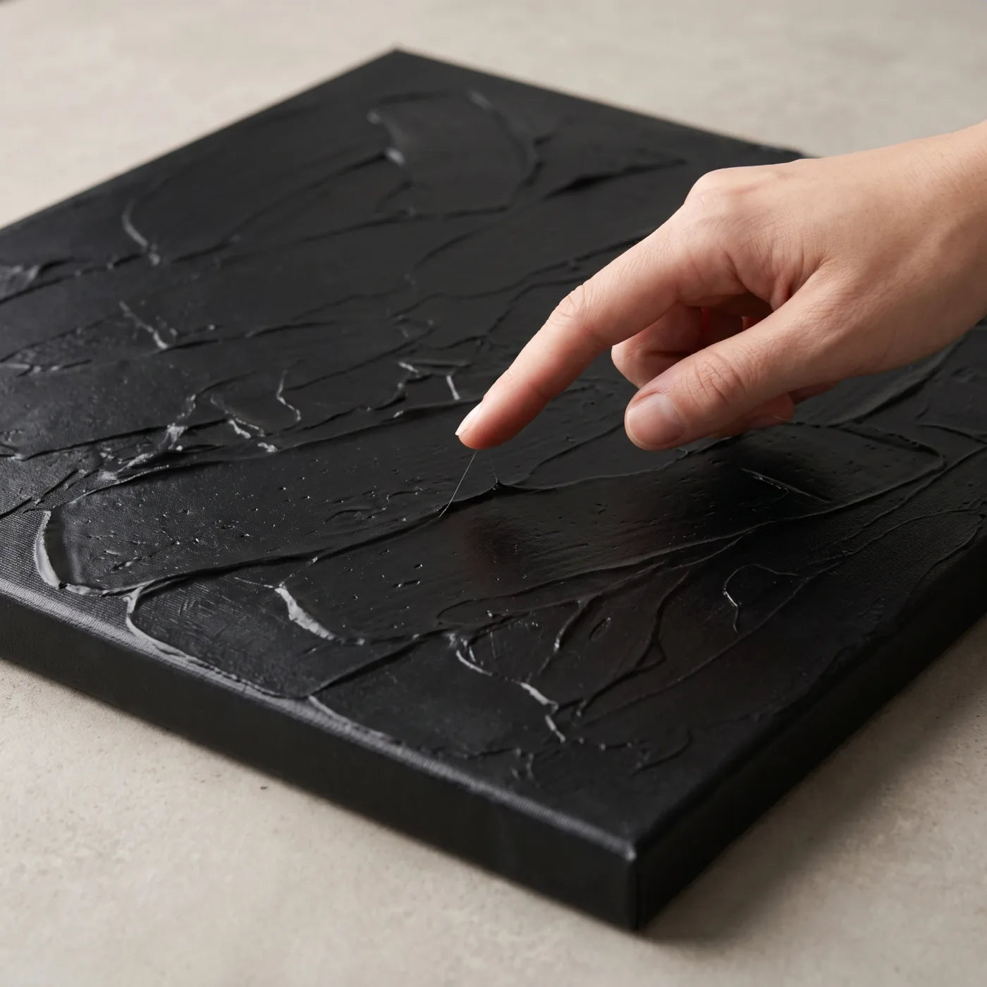 Prüfen der Klebrigkeit des Mixtions mit dem Finger auf dem schwarzen Relief