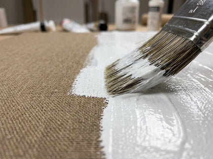 Auftragen von weißem Acryl-Gesso auf die Baumwollleinwand